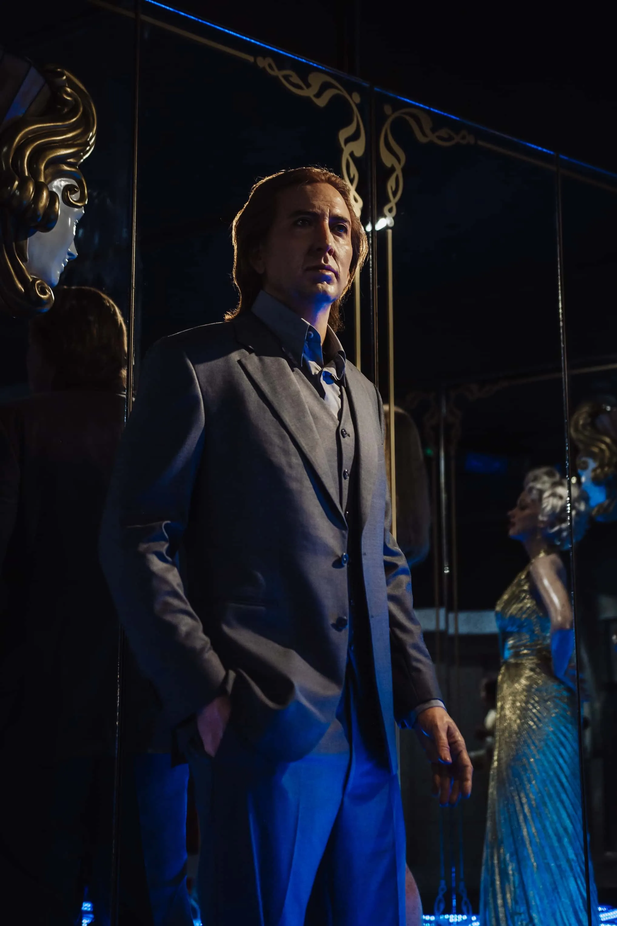 Wax figure of Nicolas Cage in a grey suit, dramatically lit in blue at WAX Museum of Legends Colmar