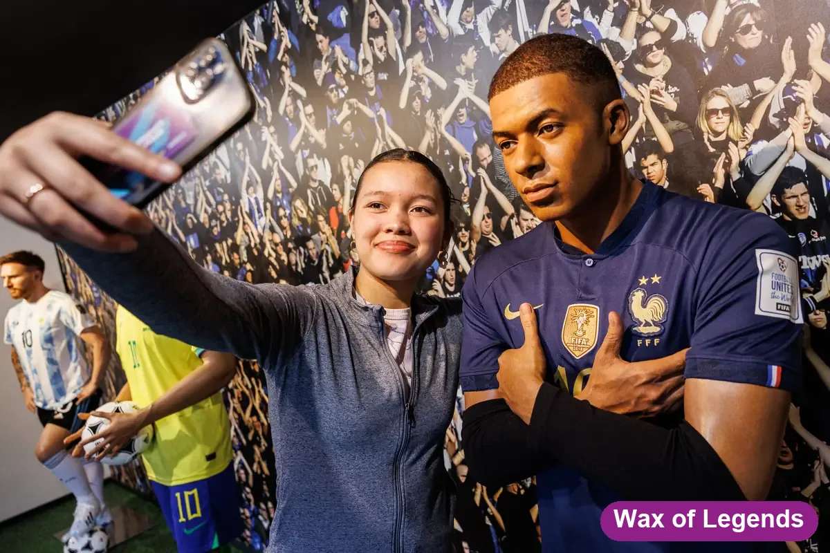Visiteuse en selfie avec la statue de cire de Mbappé et des supporters — Wax of Legends Colmar