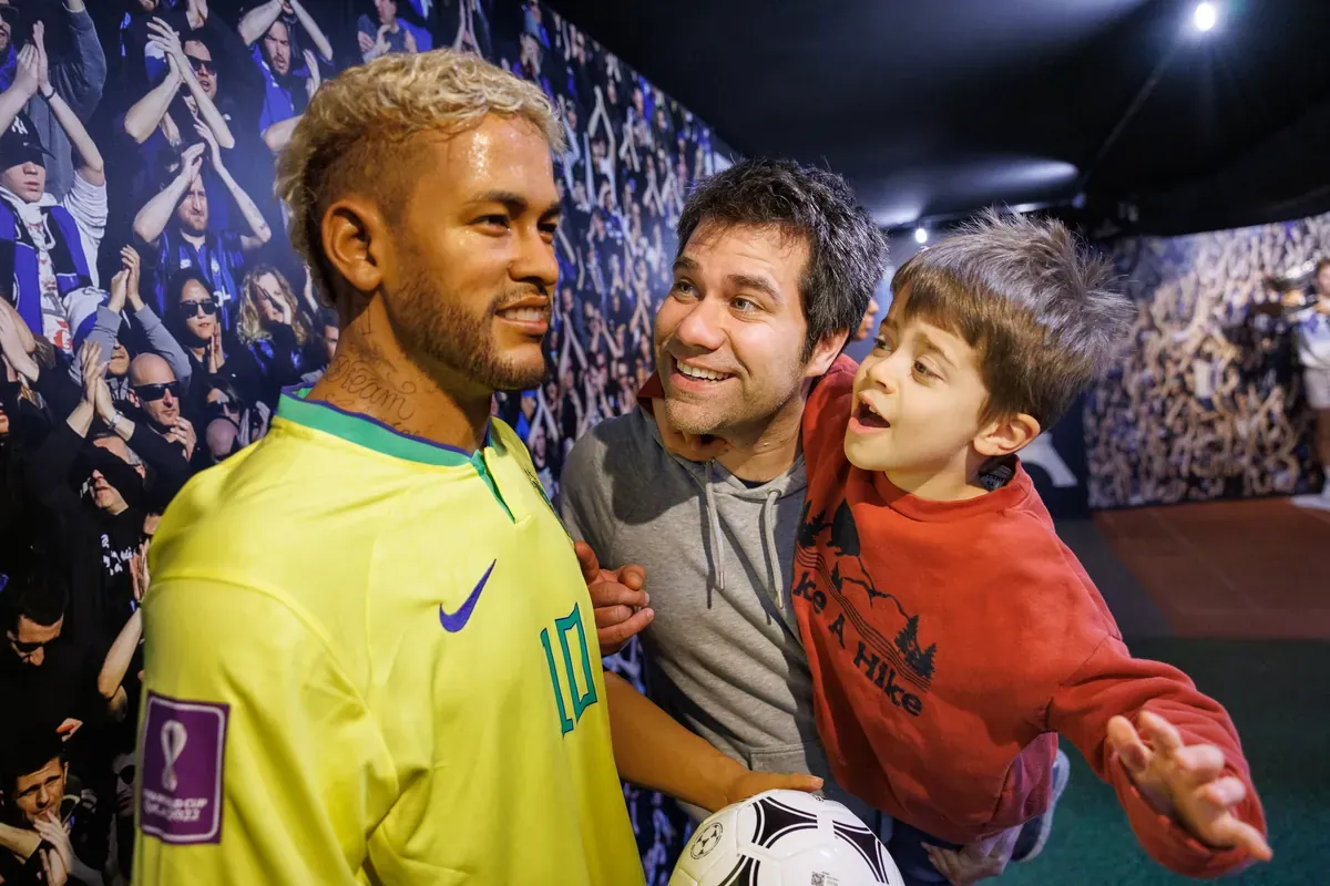 Vater und Kind machen ein Selfie mit der Wachsfigur von Neymar im Brasilien-Trikot — Wax of Legends Colmar