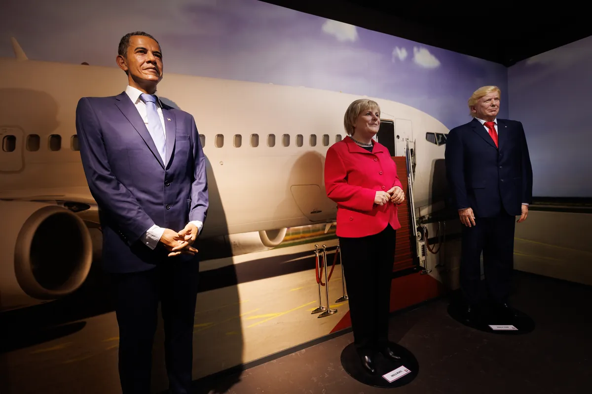 Wachsstatuen von Barack Obama, Angela Merkel und Donald Trump vor einem Flugzeug im Wax of Legends in Colmar