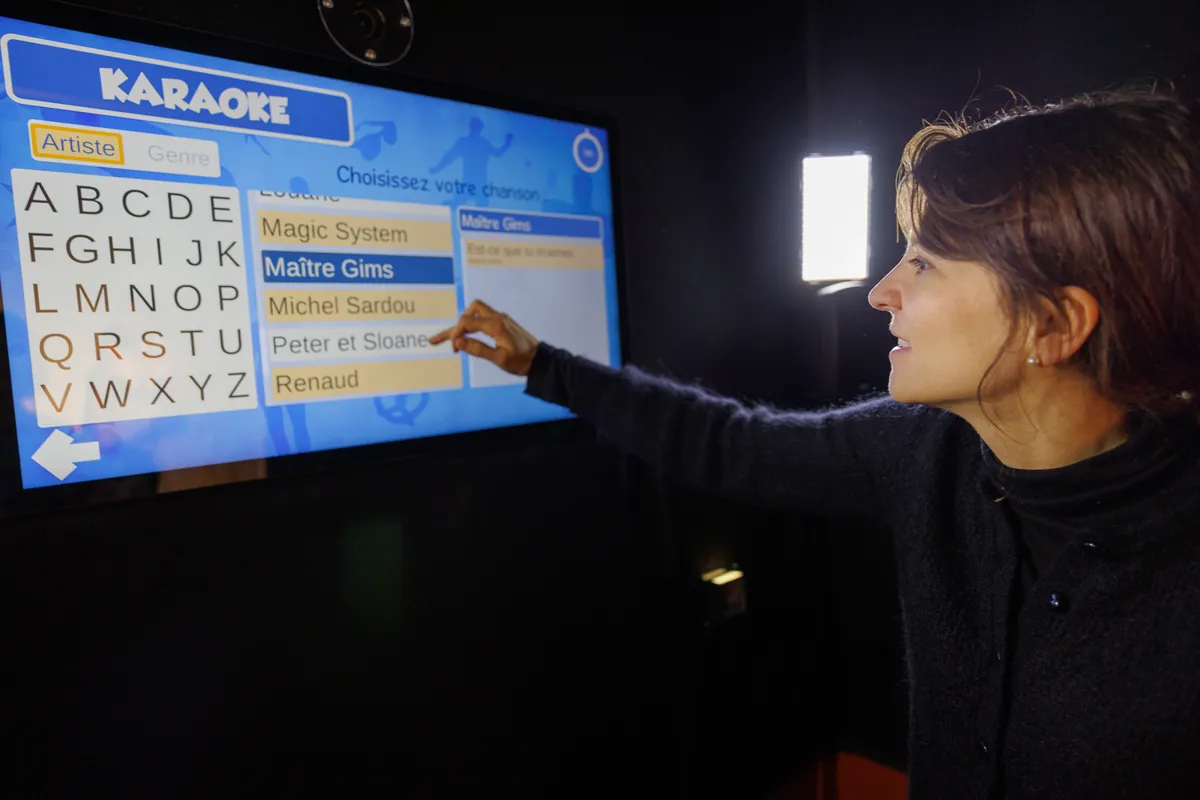 Besucherin wählt ihren Song auf dem Touchscreen des Karaoke im Wax of Legends in Colmar