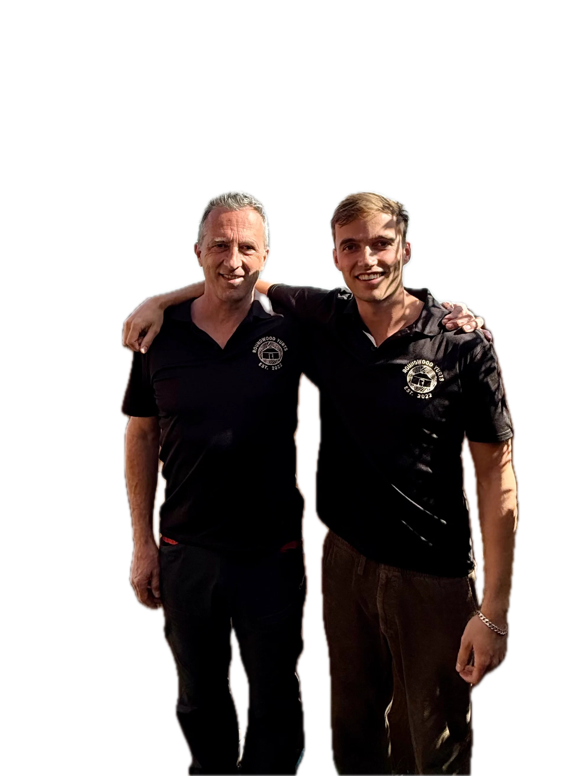 Two men smiling with arms around each other wearing matching black polo shirts with Roundwood Yurts logo.