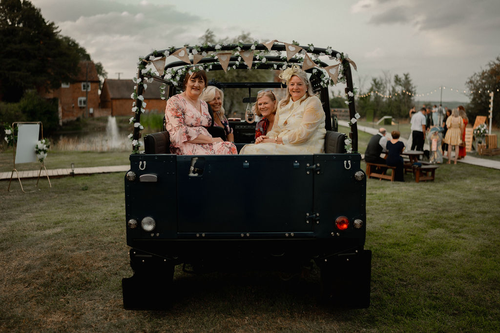 Wedding guests enjoying the soft-top blue land rover