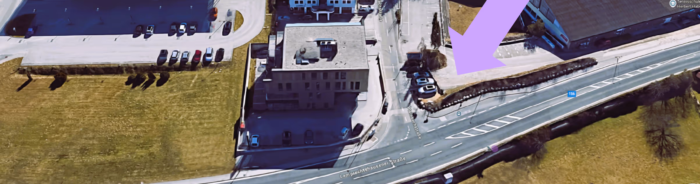 Luftaufnahme eines Gebäudes an der Lampechtshausener Straße mit Parkplätzen und umliegenden Grünflächen, violetter Pfeil zeigt auf einen Parkplatz.