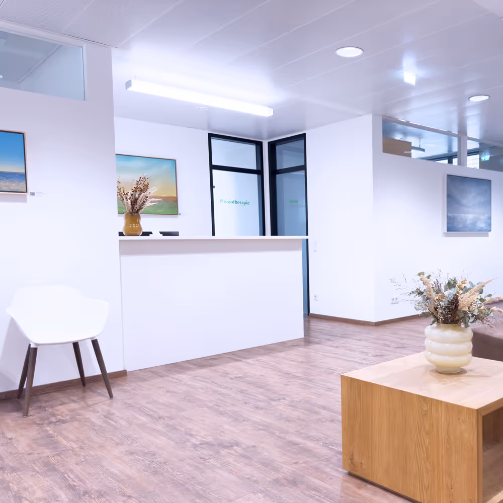 Moderne Praxisrezeption mit weißem Empfangstresen, Holzfußboden, weißen Wänden, Stuhl, Bilder und Dekoration mit Blumenvasen.