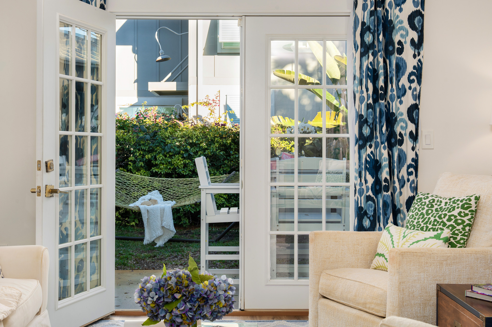 Bright Jacksonville Beach vacation rental living room with open French doors leading to patio and hammock