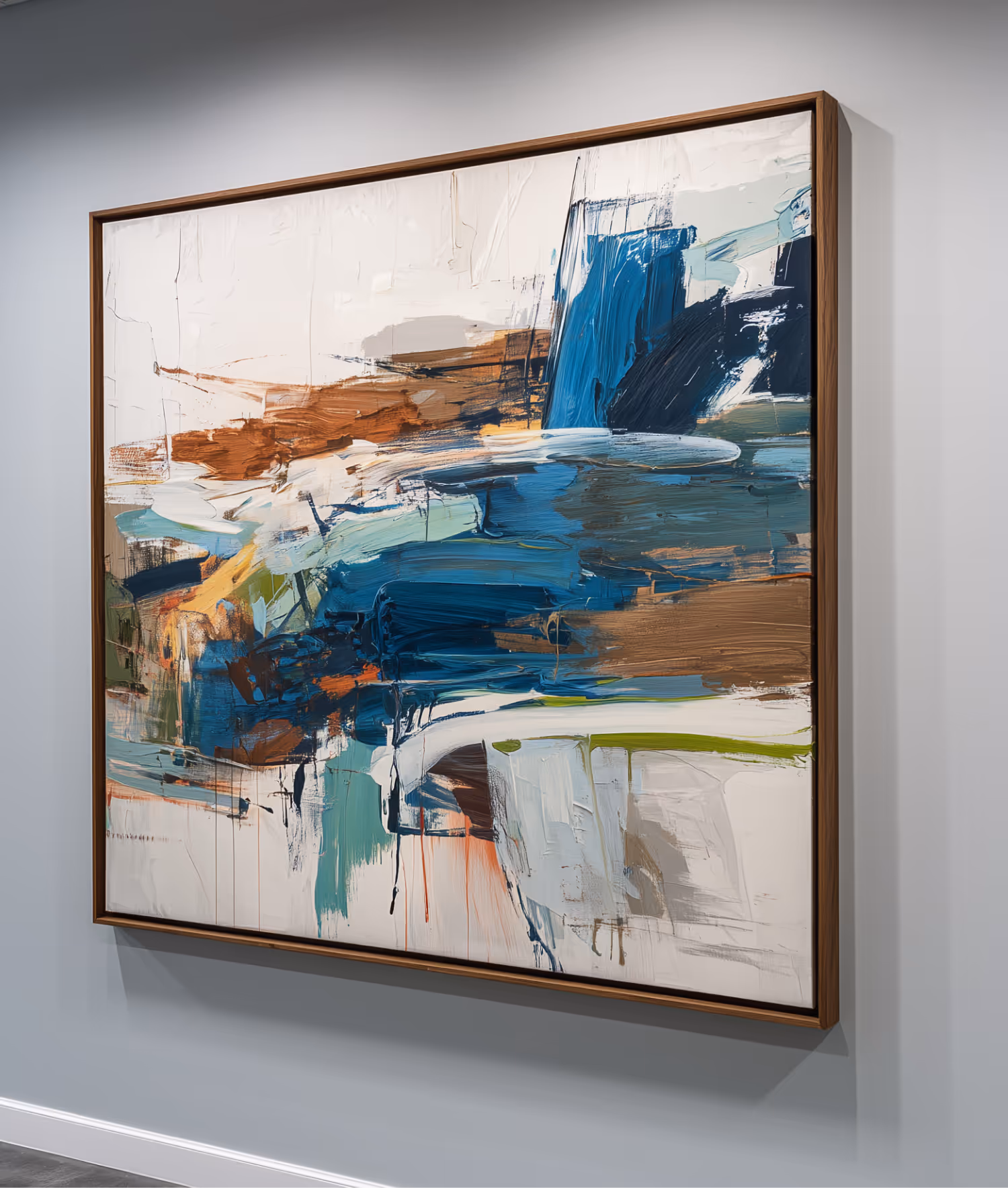 Abstract painting with bold brushstrokes in blue, brown, white, and green hues in a wooden frame on a light gray wall.