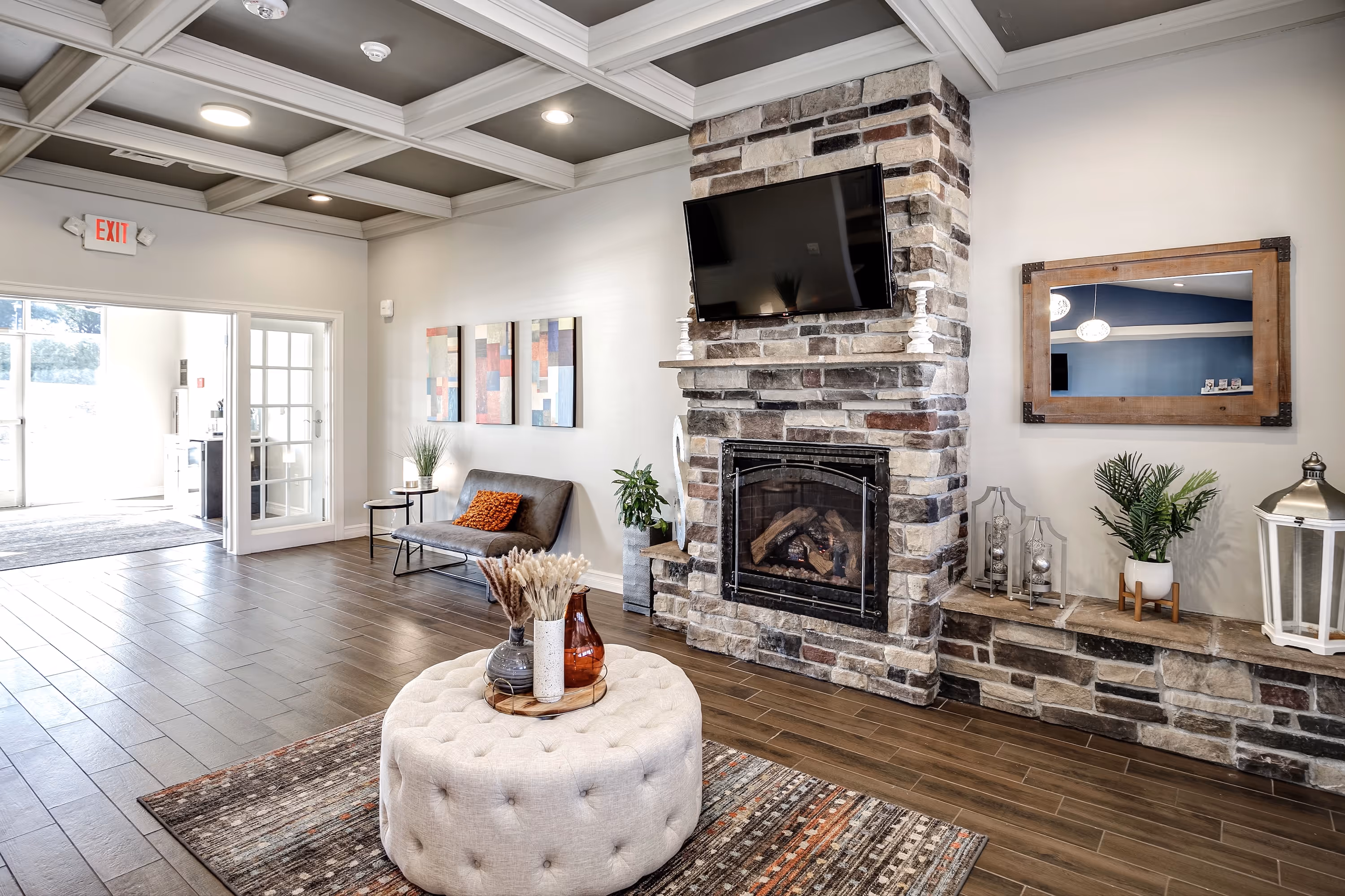 Clubhouse with seating area and kitchen area with a television on the wall.