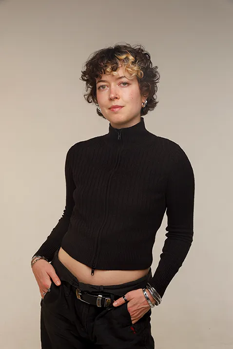 A portrait photo of Mila Emmerich standing in front of a white background.