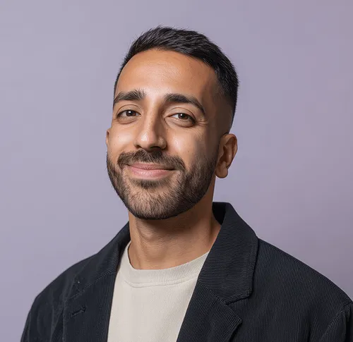 A professionally dressed man smiling confidently, reflecting reliability and success in recruitment and HR solutions.