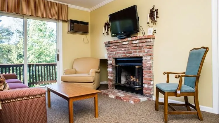 2 chairs by the fireplace with balcony view