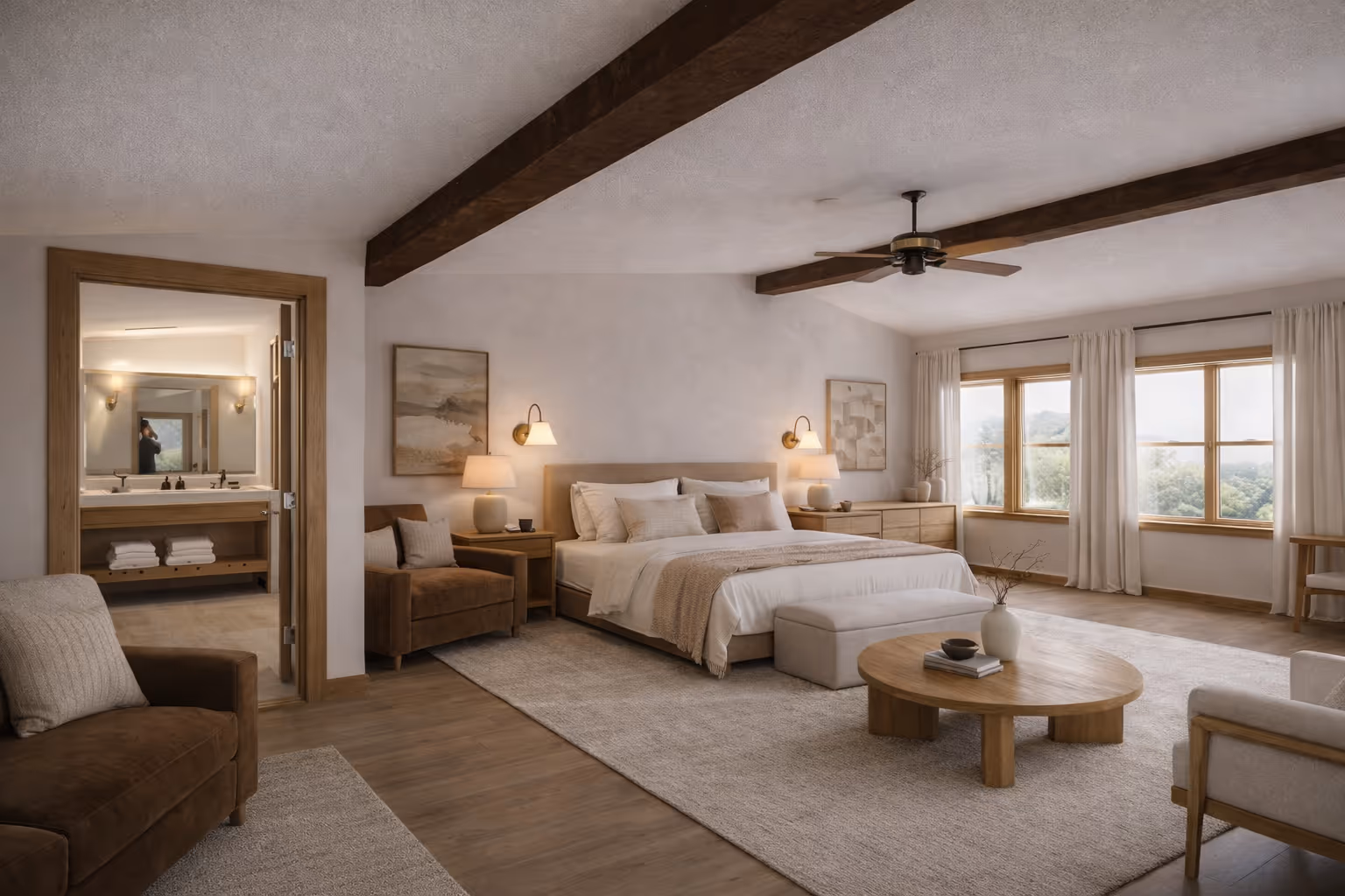 Spacious bedroom with large bed, two armchairs, round coffee table, and windows showing greenery outside.