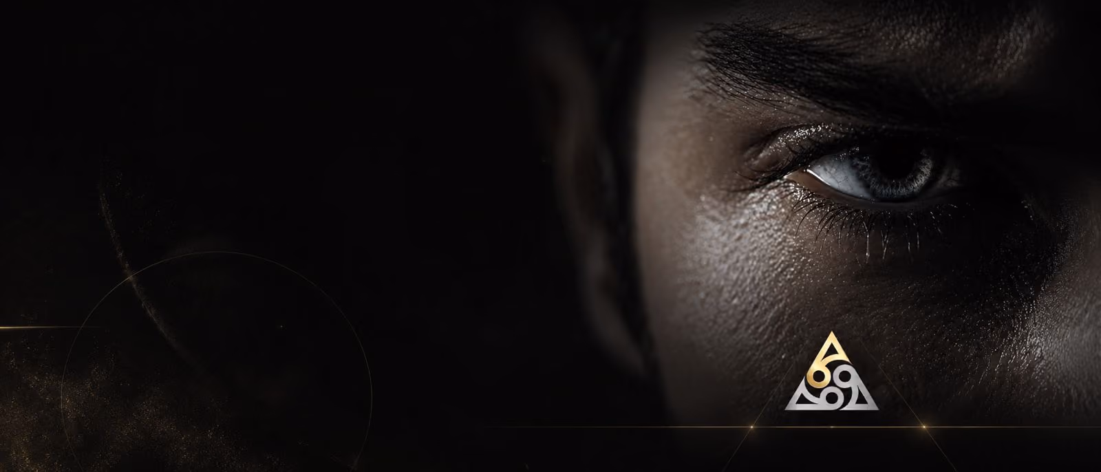 Close-up of a human eye with dark lighting and a gold and silver triangular logo underneath.