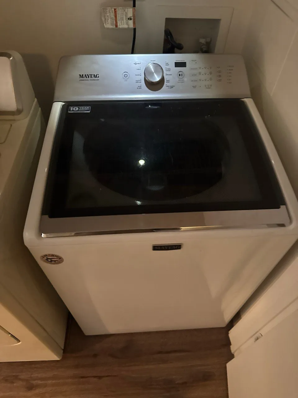 White Maytag top-load washing machine with digital control panel and glass lid.