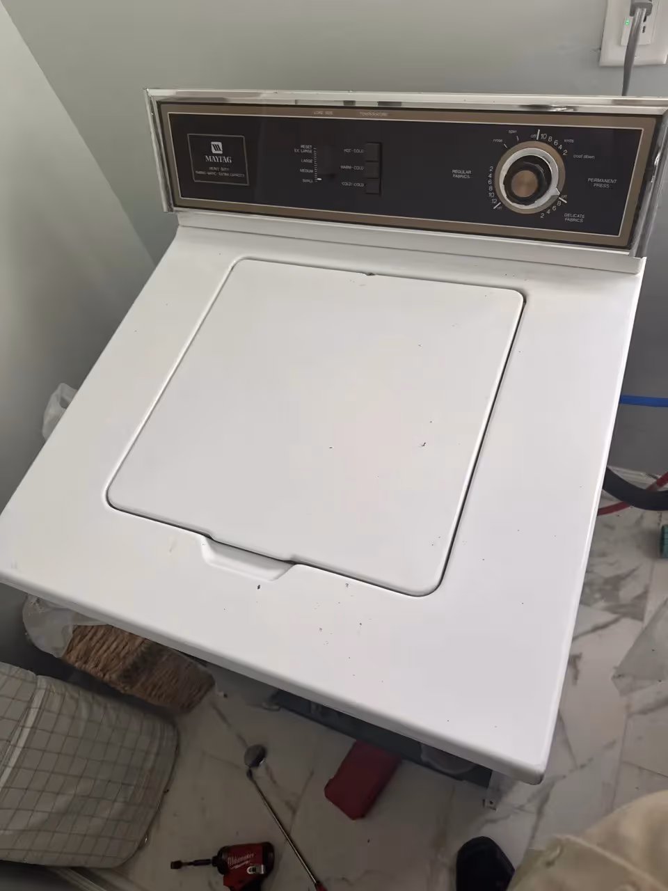 Older white Maytag top-load washer with classic dial controls.
