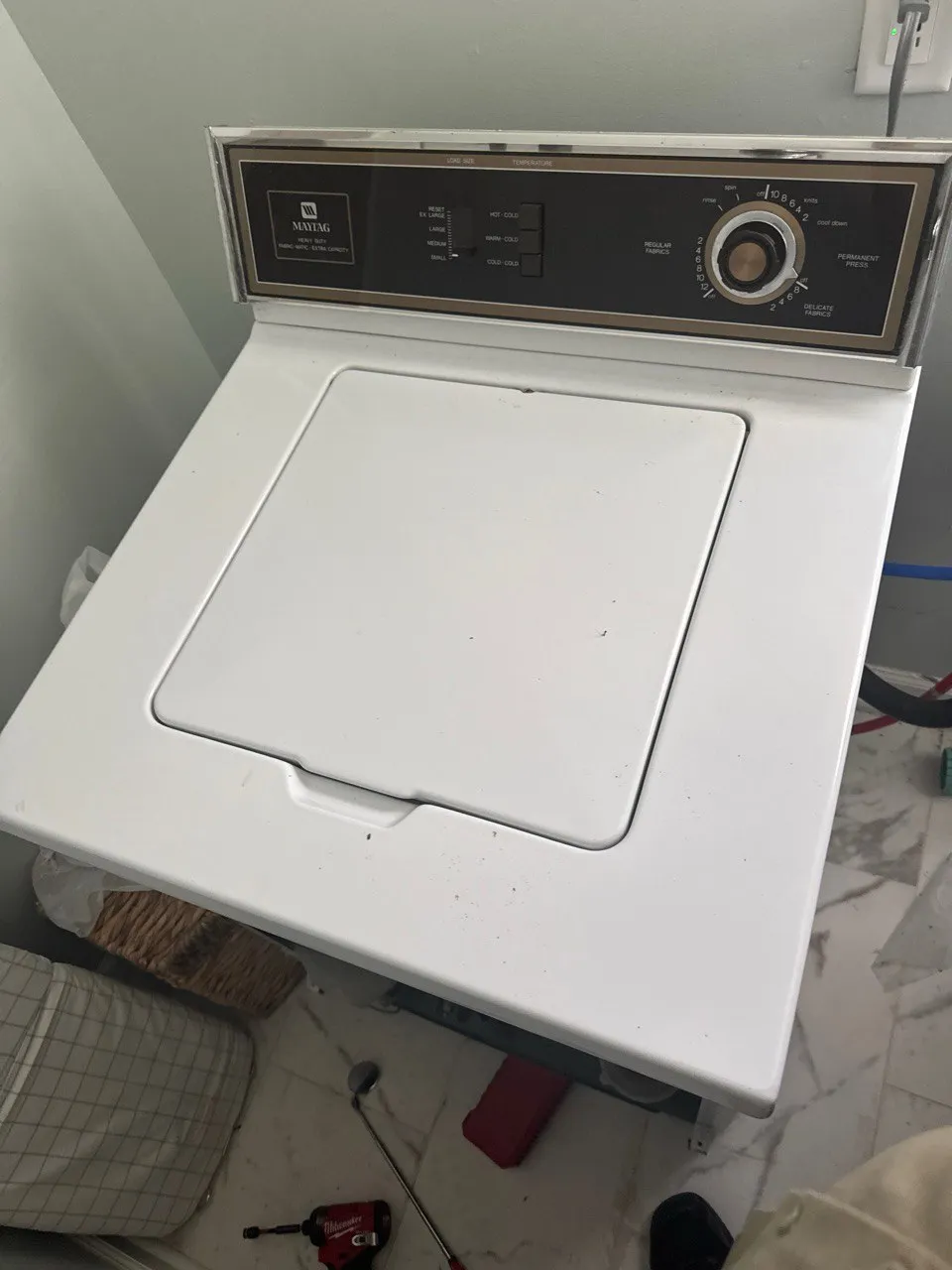 Older white Maytag top-load washer with classic dial controls.