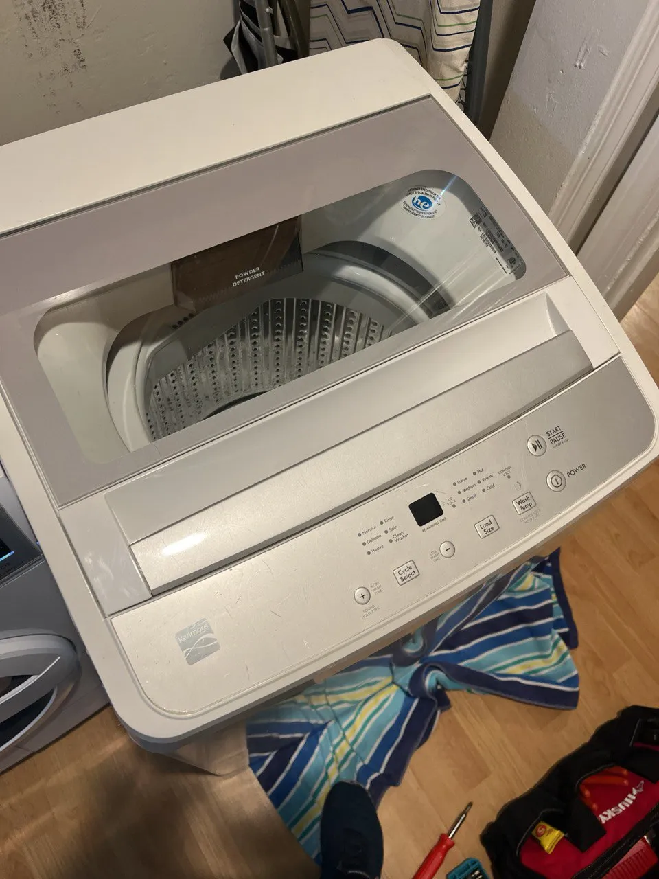 Modern Kenmore top-load washer with glass lid and digital control panel.