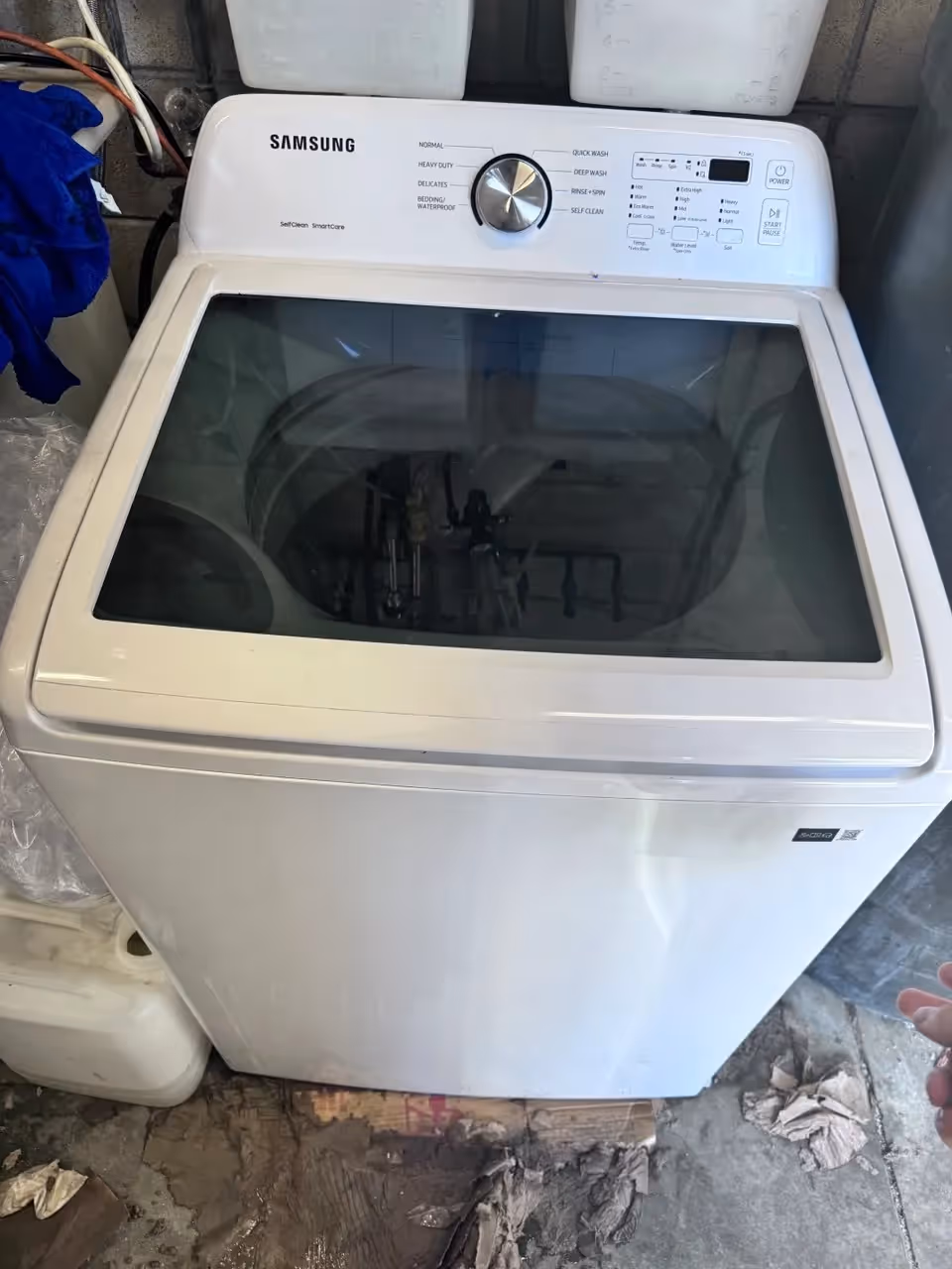 Samsung top-load washing machine with glass lid and control dial.