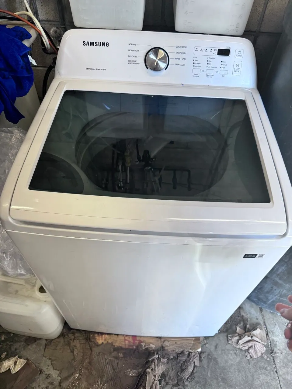 Samsung top-load washing machine with glass lid and control dial.