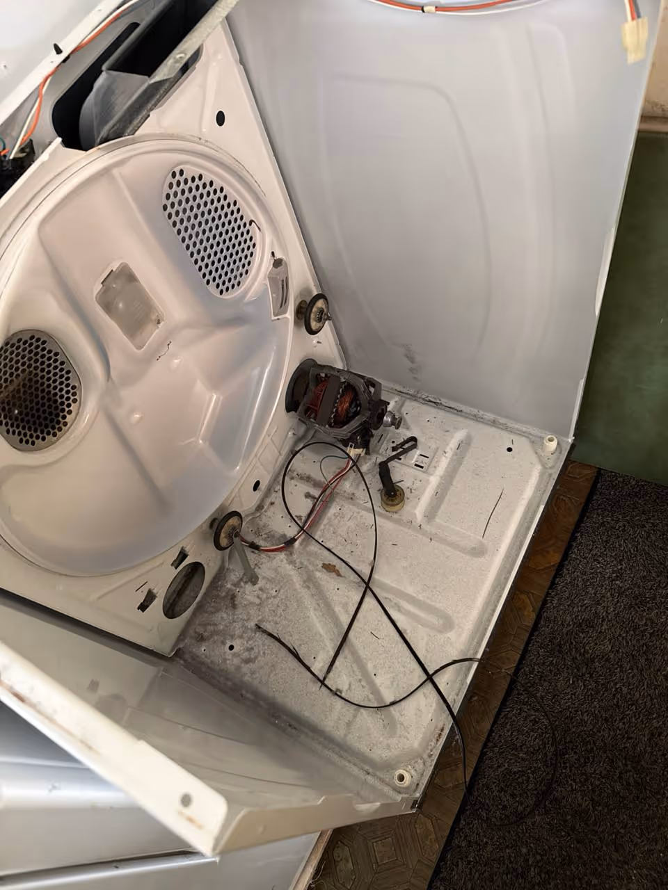 Dryer disassembled during professional repair service in Cornelius NC showing motor and internal components