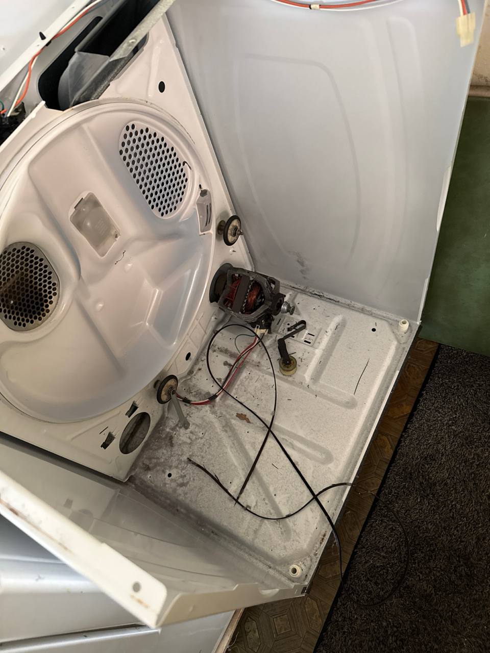 Dryer disassembled during professional repair service in Cornelius NC showing motor and internal components