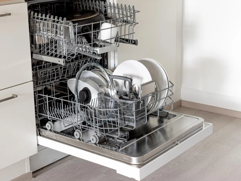 Open dishwasher with clean dishes inside after repair service in Cornelius kitchen