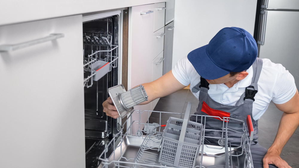 Technician repairing dishwasher and cleaning filter