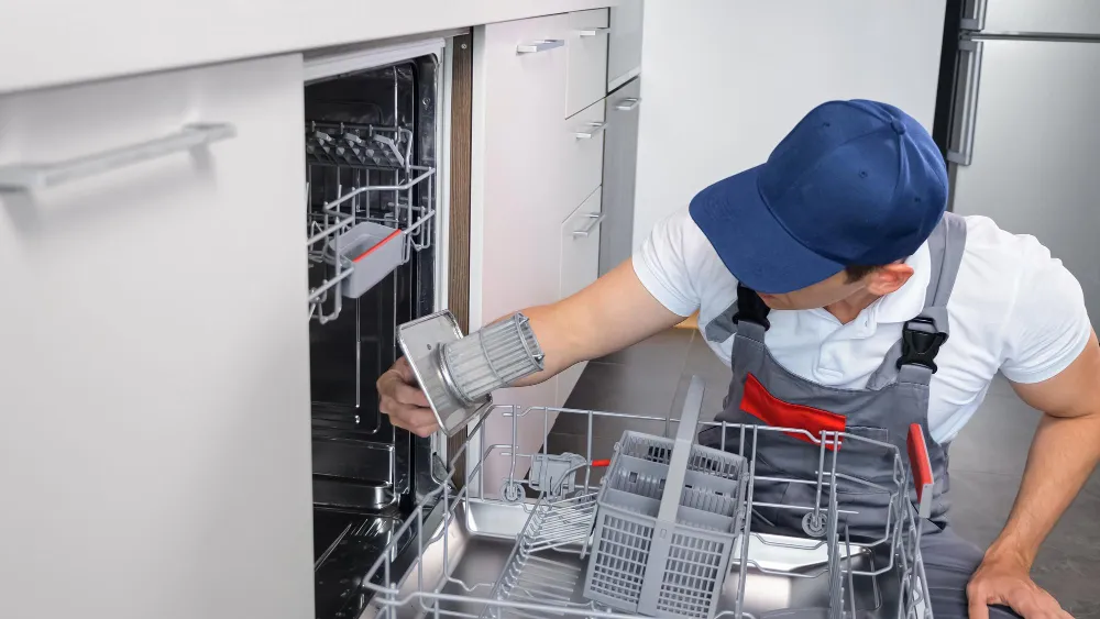 Technician repairing dishwasher and cleaning filter