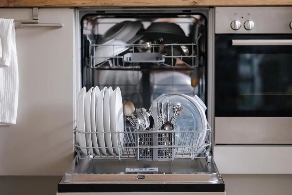 Open dishwasher loaded with clean dishes after professional repair service