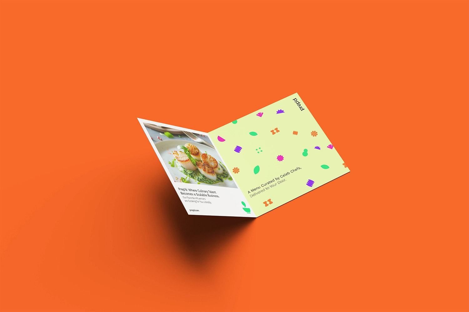 Open brochure with bright patterned interior on orange surface.