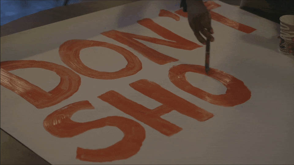 Painting a protest sign.