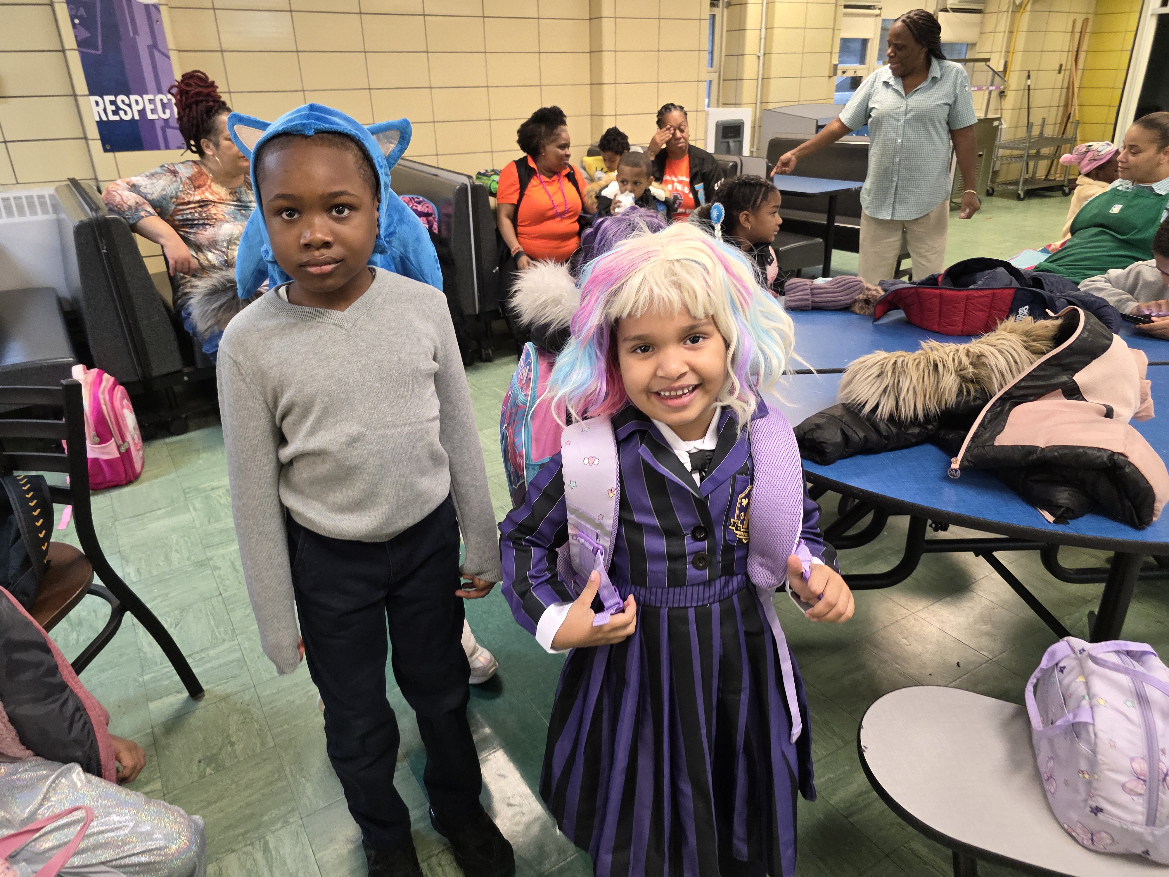 Two students in Halloween costumes posing in school cafeteria