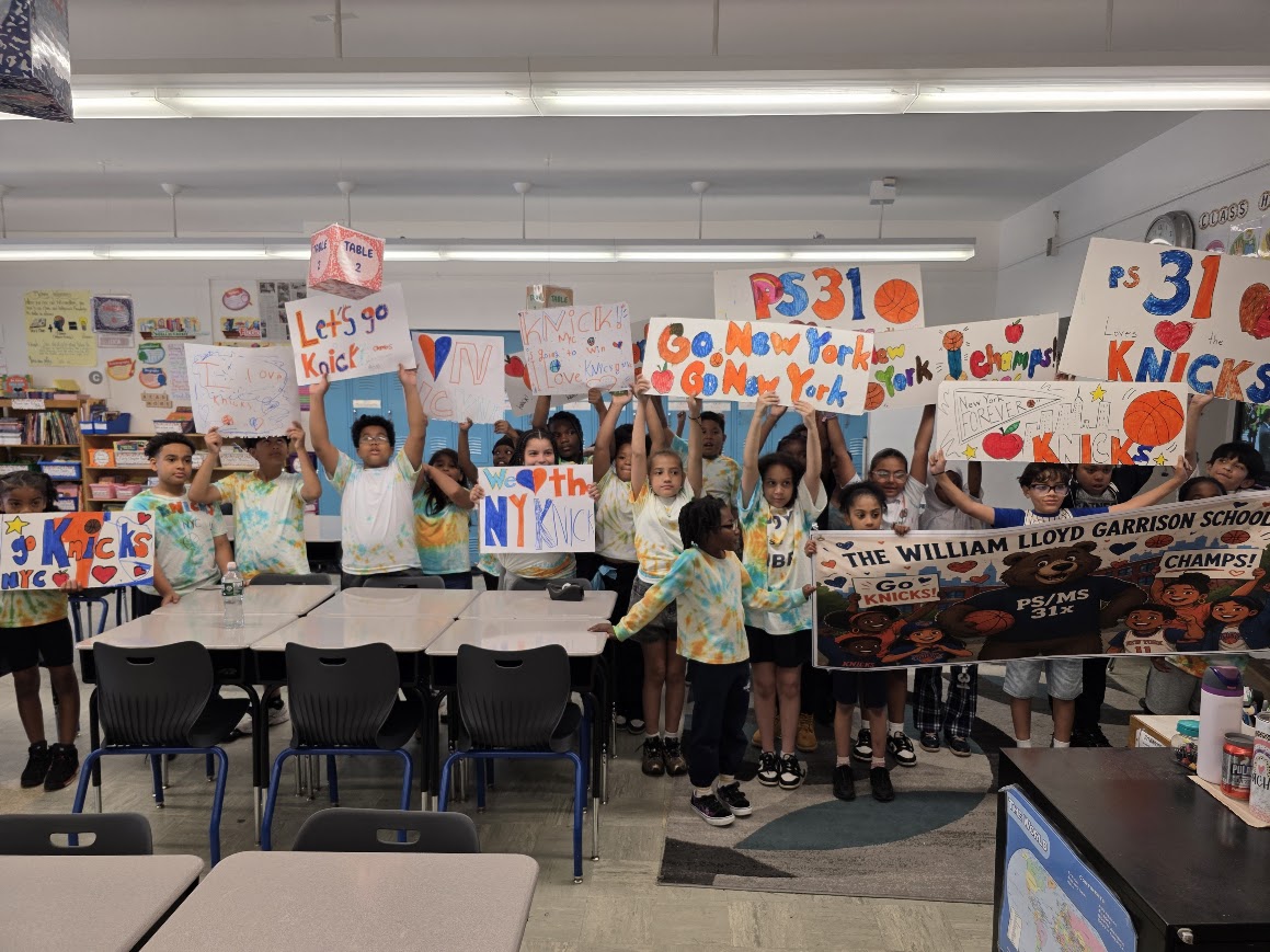 PS 31 students holding handmade Go Knicks signs in classroom