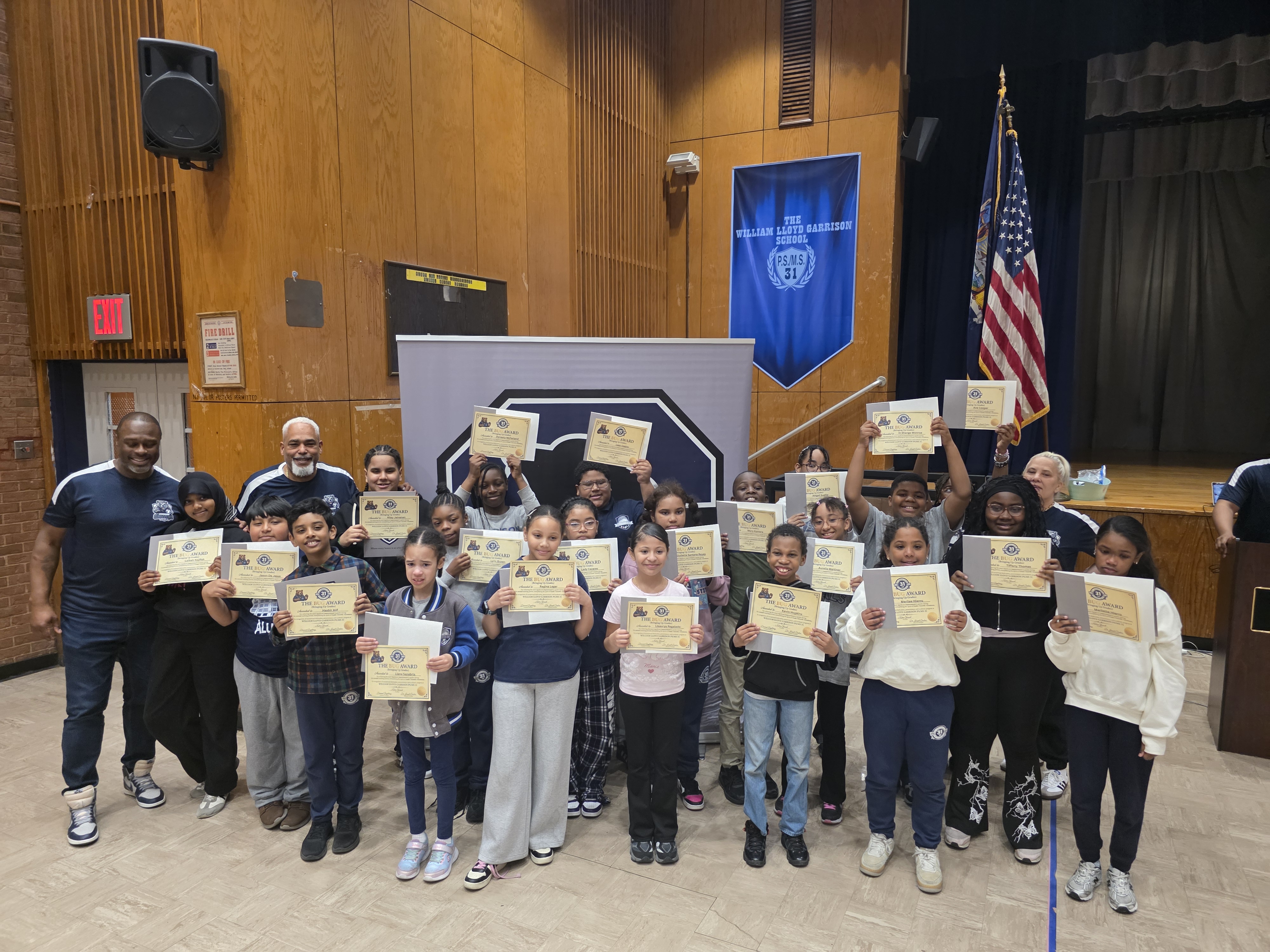 Students and staff holding award certificates at PS MS 31 ceremony