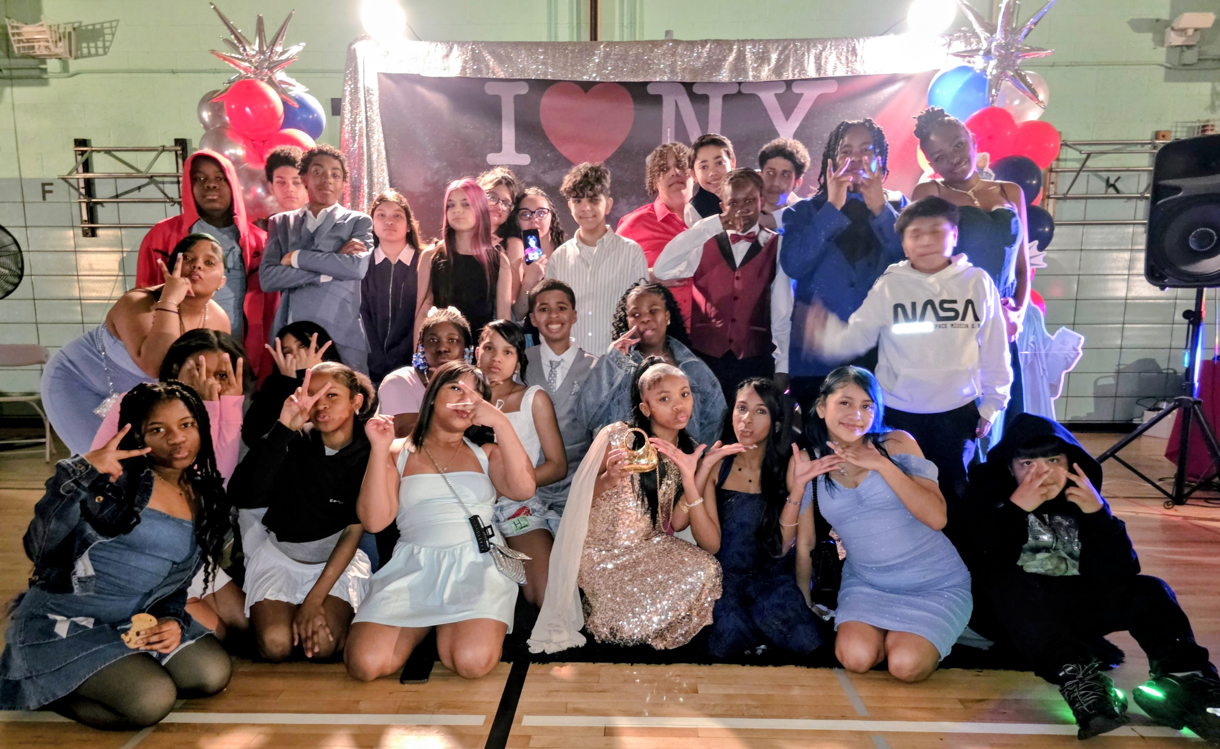 Students pose together at school spring formal with I Love NY backdrop