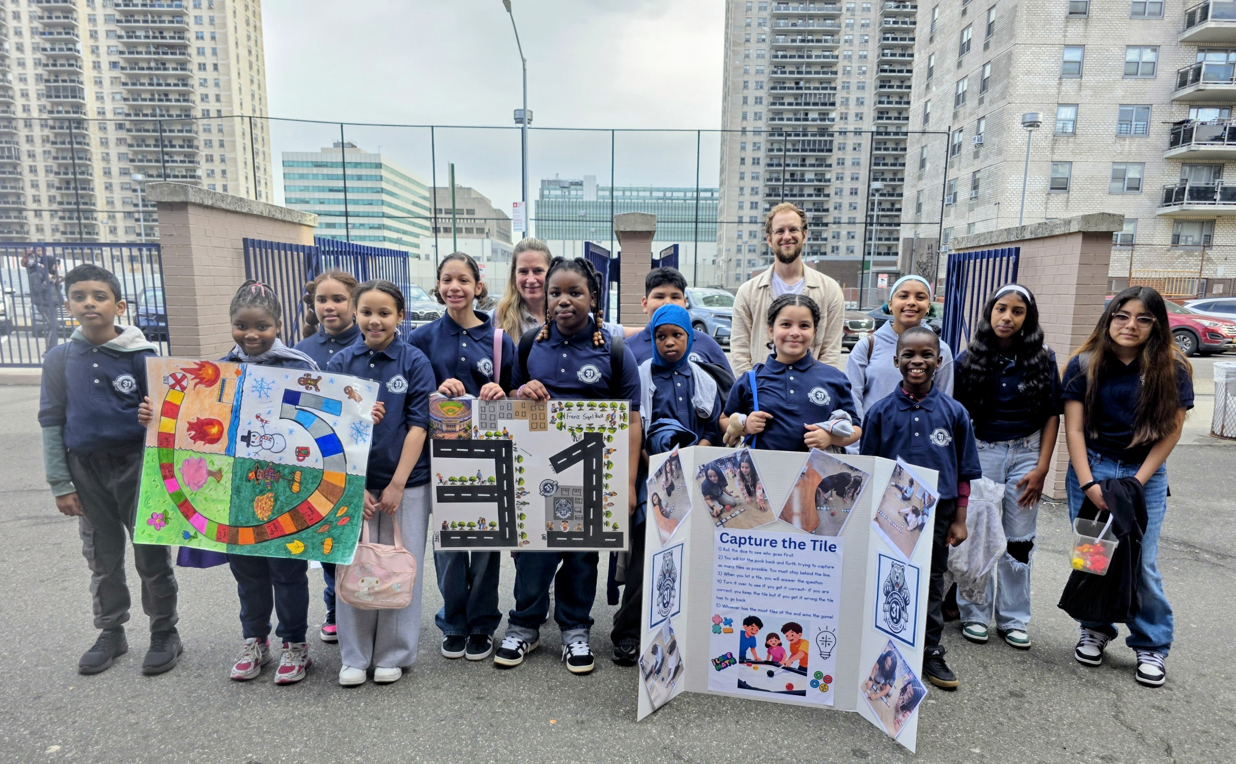 Students and teachers displaying board game projects at outdoor math competition