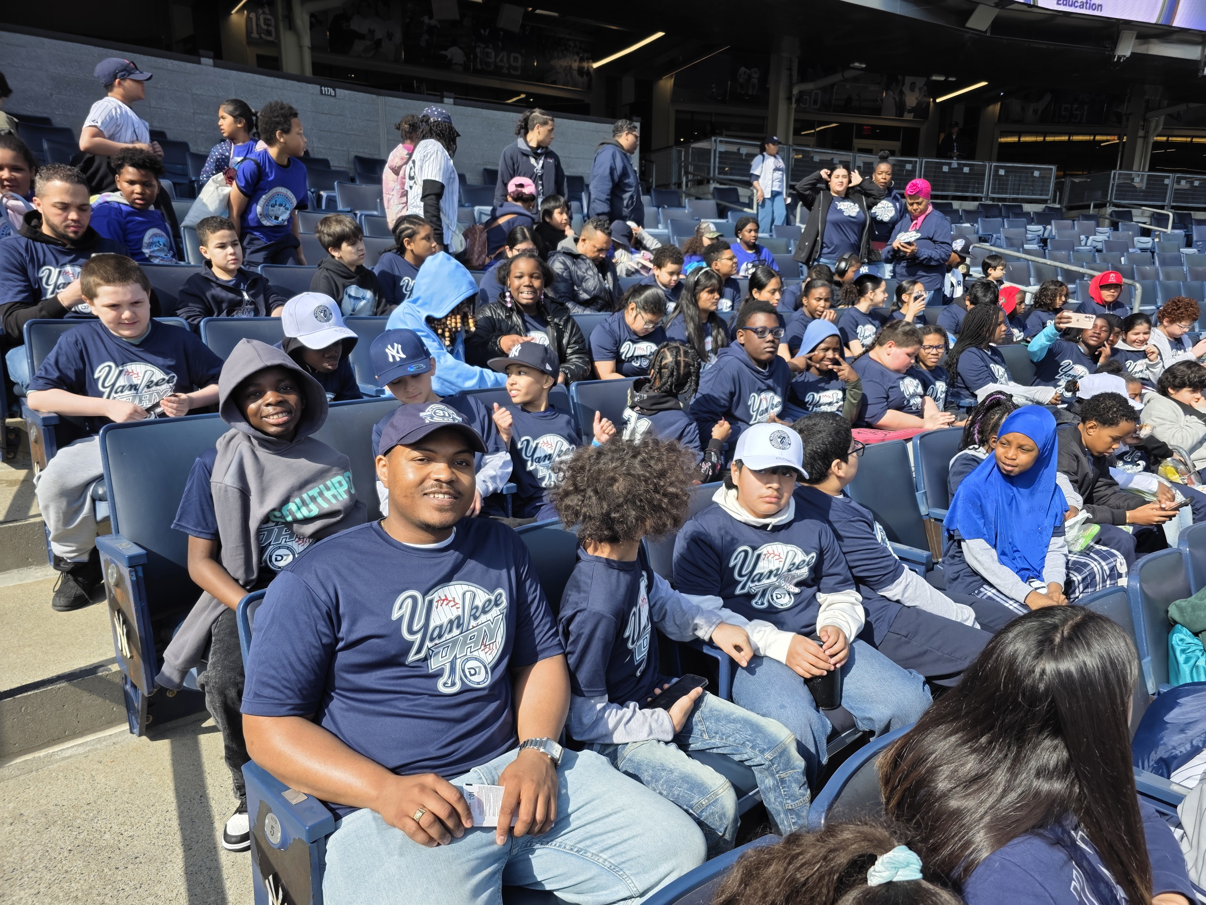 Students and chaperones wearing Yankee fan shirts at Yankee Stadium