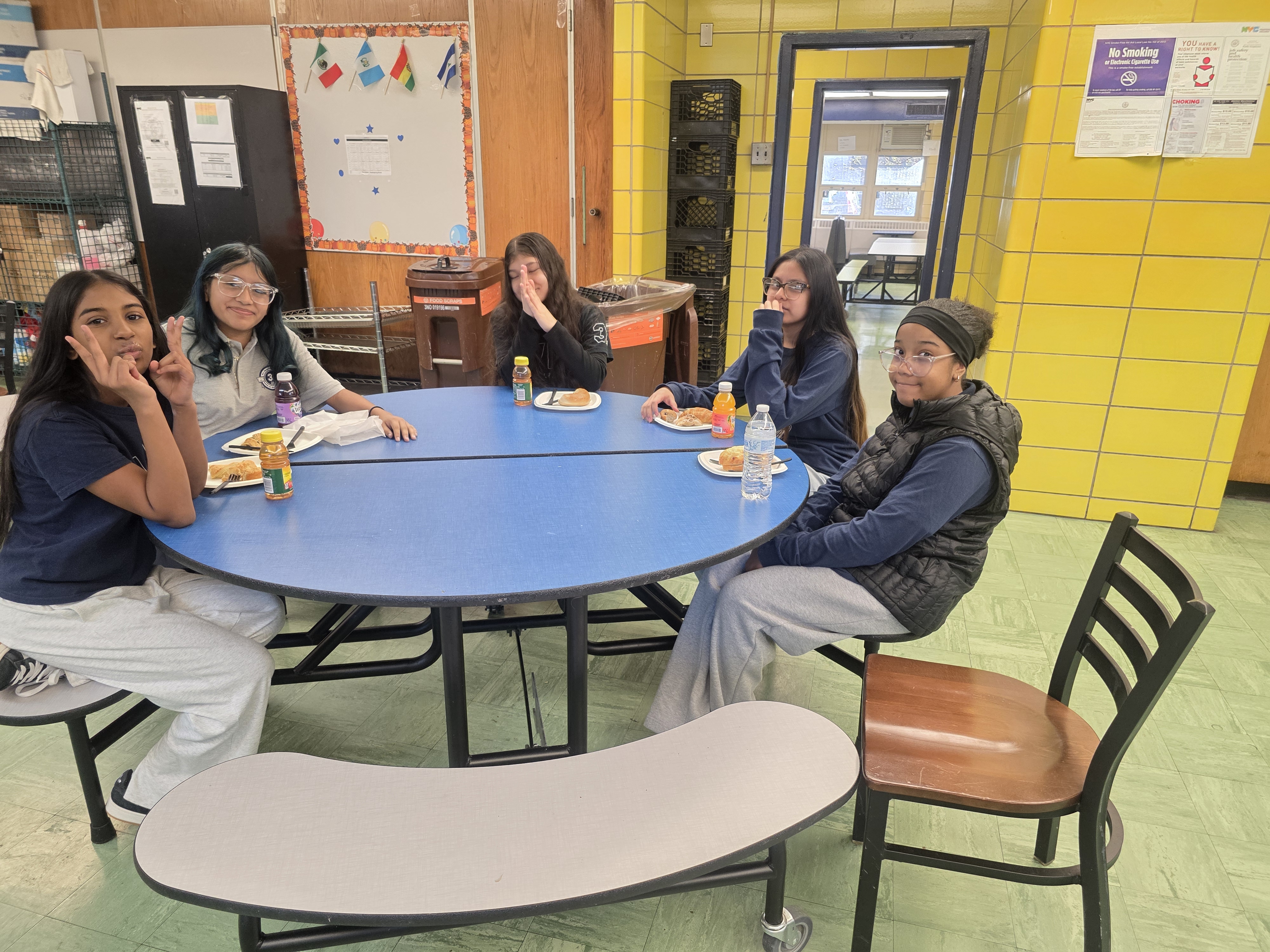 Five middle school students eating together at cafeteria table during Honor Roll Breakfast