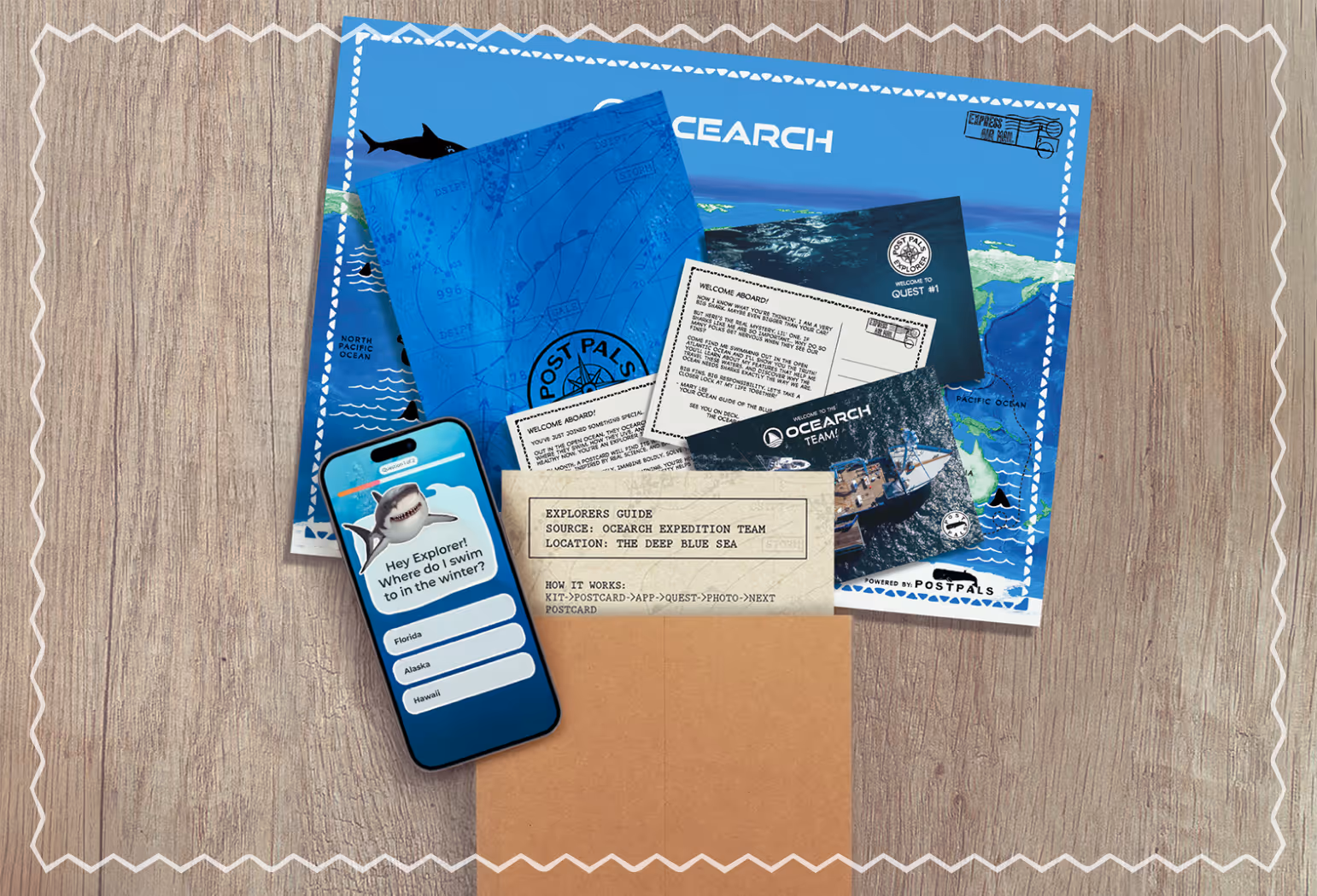 The Ocearch Adventure Kit including a world map, explorer and navigator guide, two postcards, and a smartphone Explorer app.