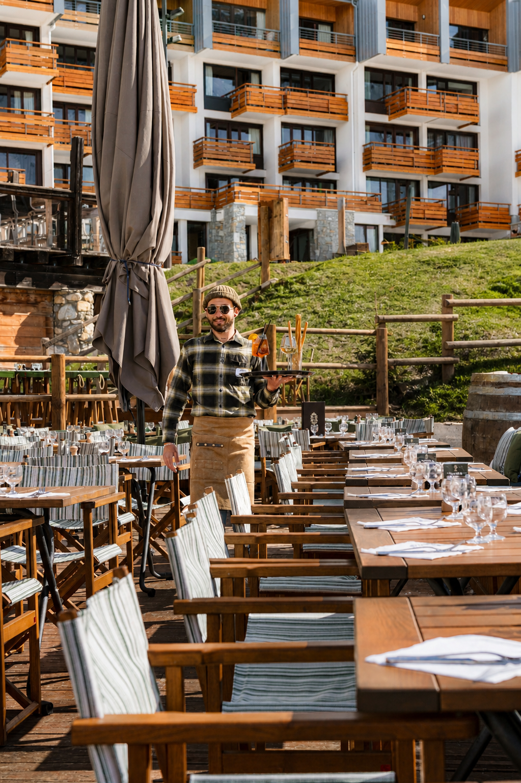 Serveur du restaurant Alberto Tignes servant des boissons sur la terrasse à Tignes Val-Claret.