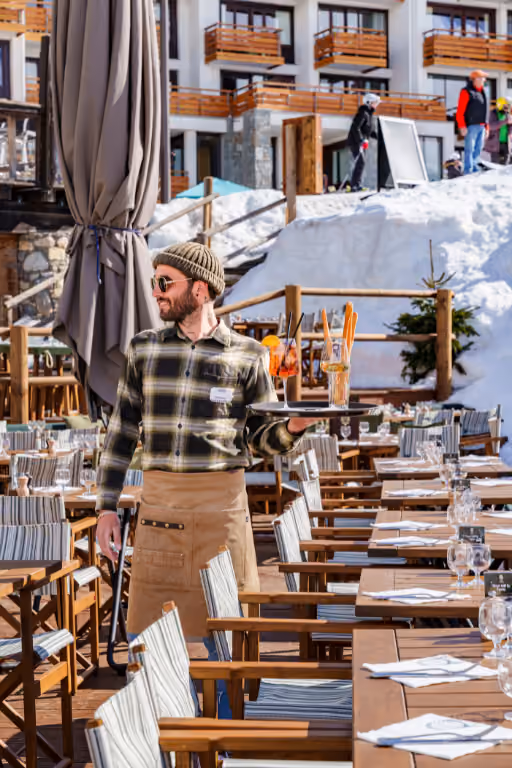 Waiter at the Alberto Tignes restaurant serving drinks on the terrace in Tignes Val-Claret.
