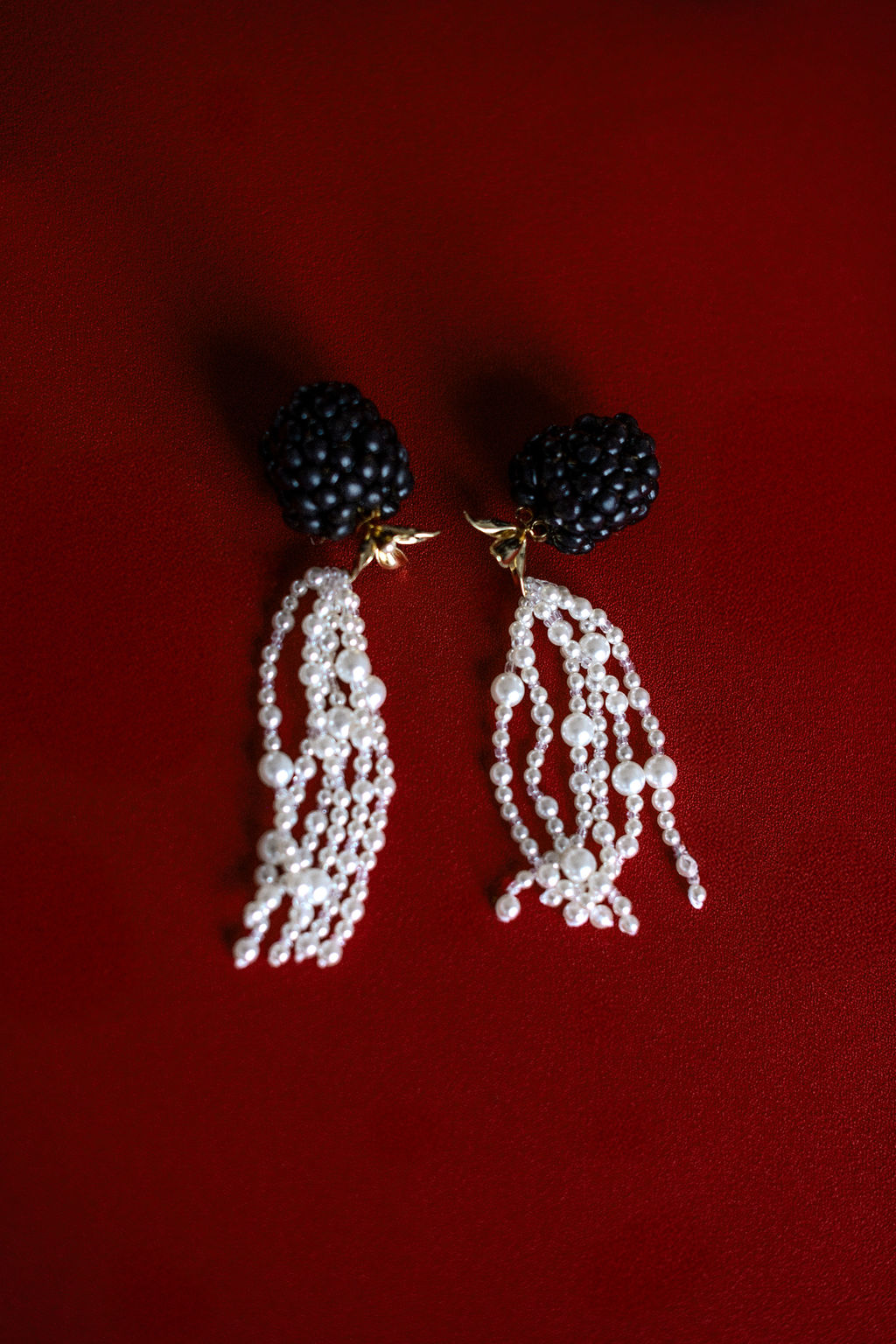 Photo d'une paire de boucle d'oreille sur fond rouge dans une ambiance baroque et vintage