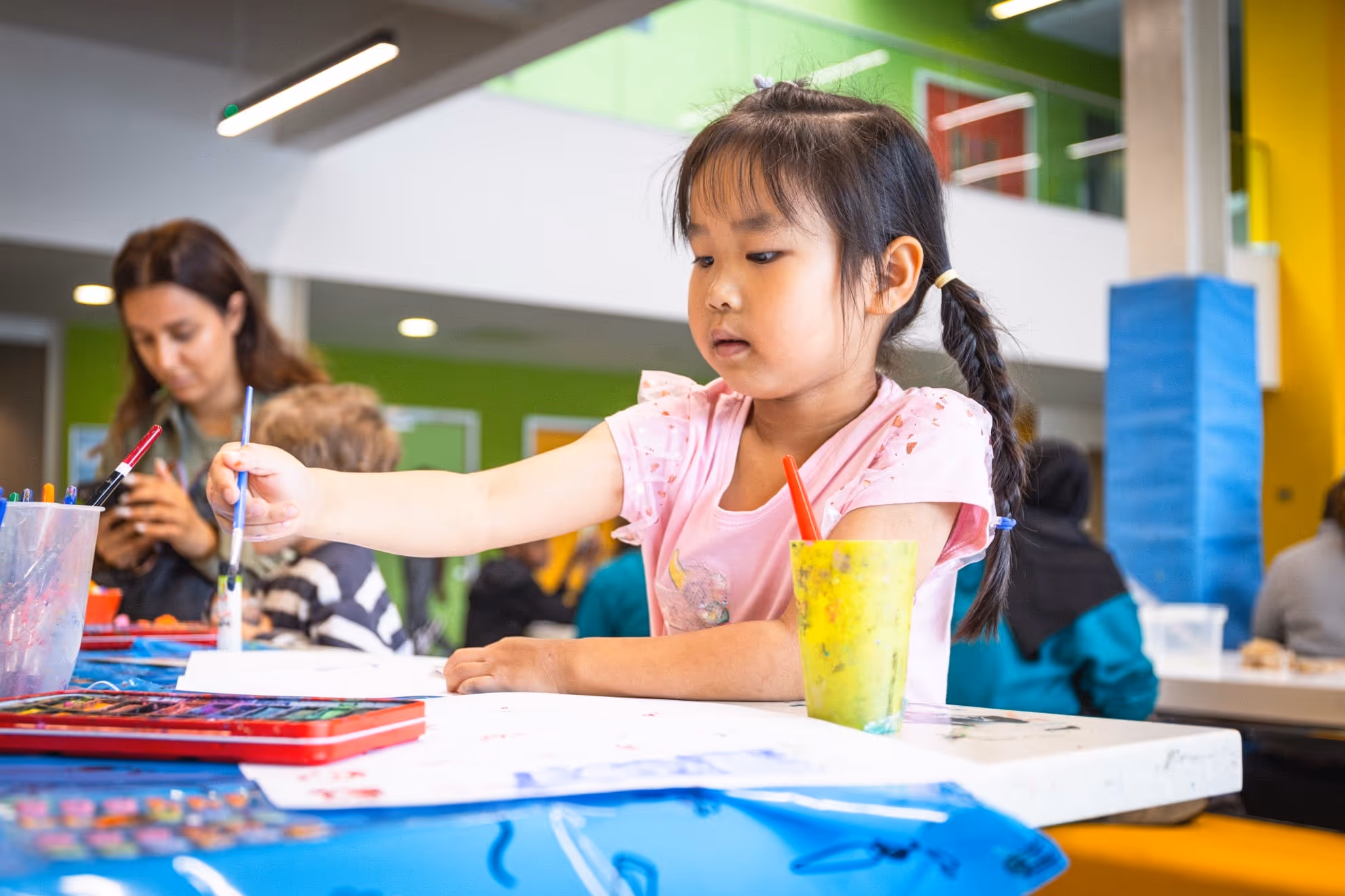 Image of a small child at the youth centre doing arts and crafts activities.