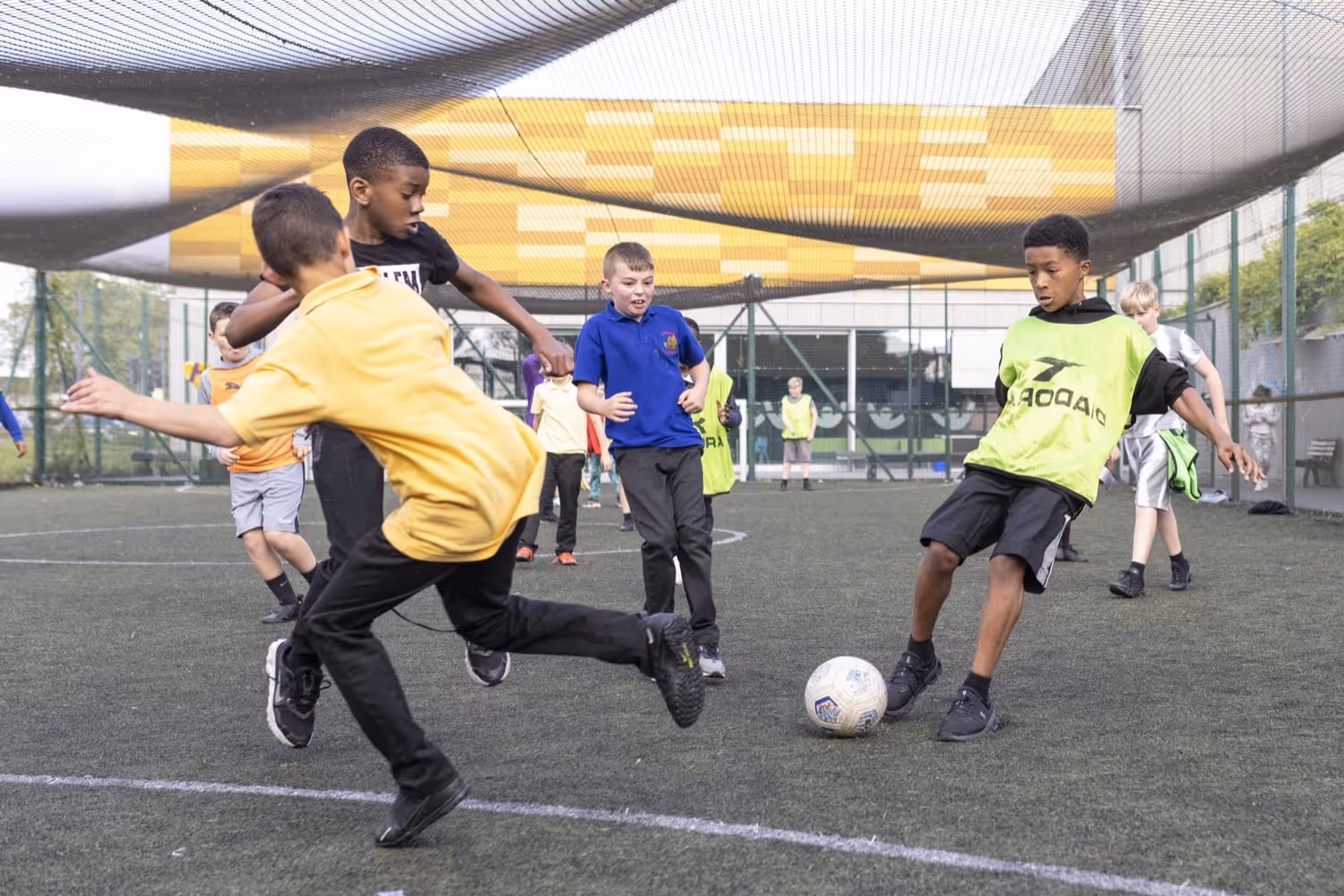 Young group of boys playing football outside.