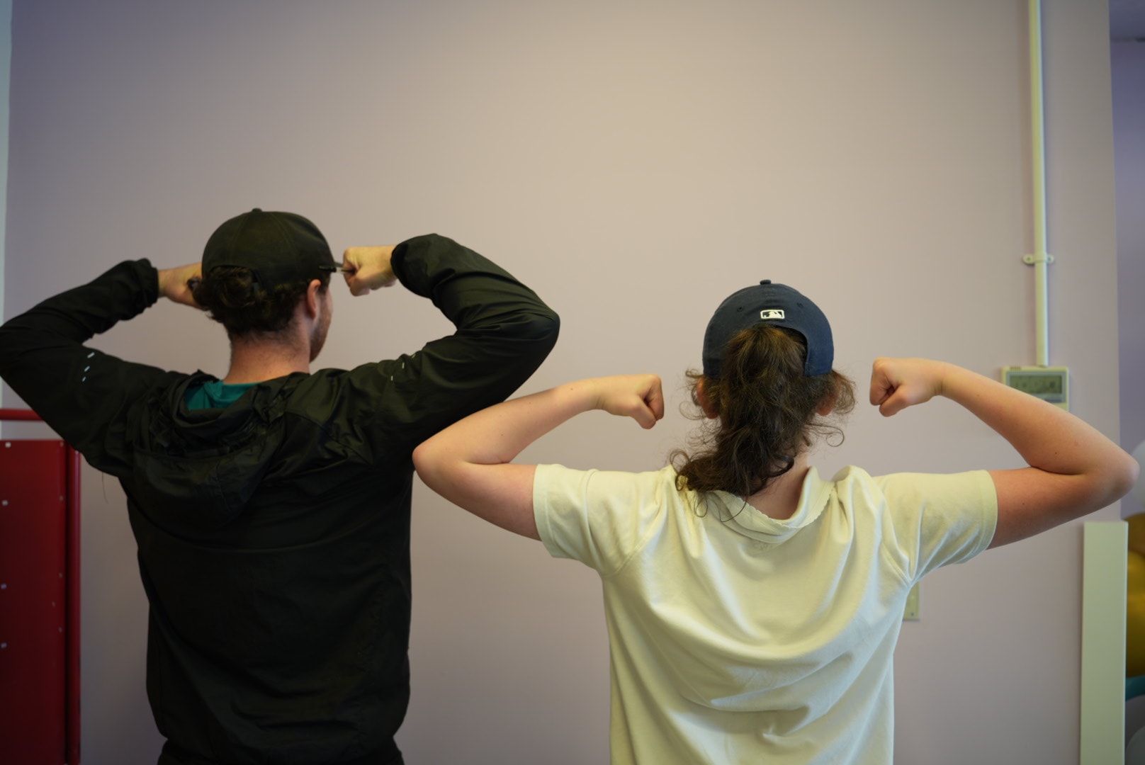 Two people with their backs to camera with arms up