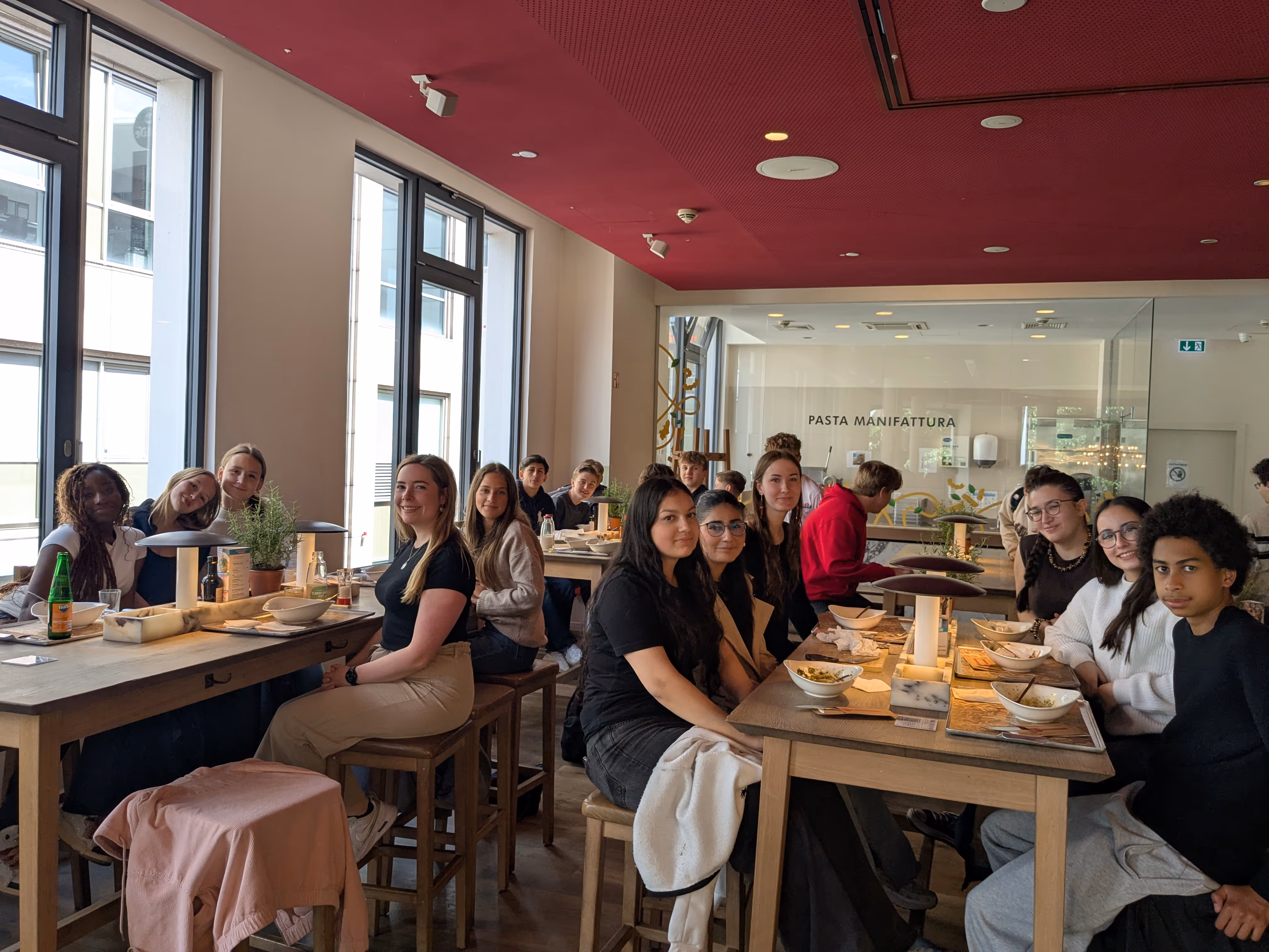 Die bilinguale Klasse sitzt im Restaurant nach einen Ausflug.