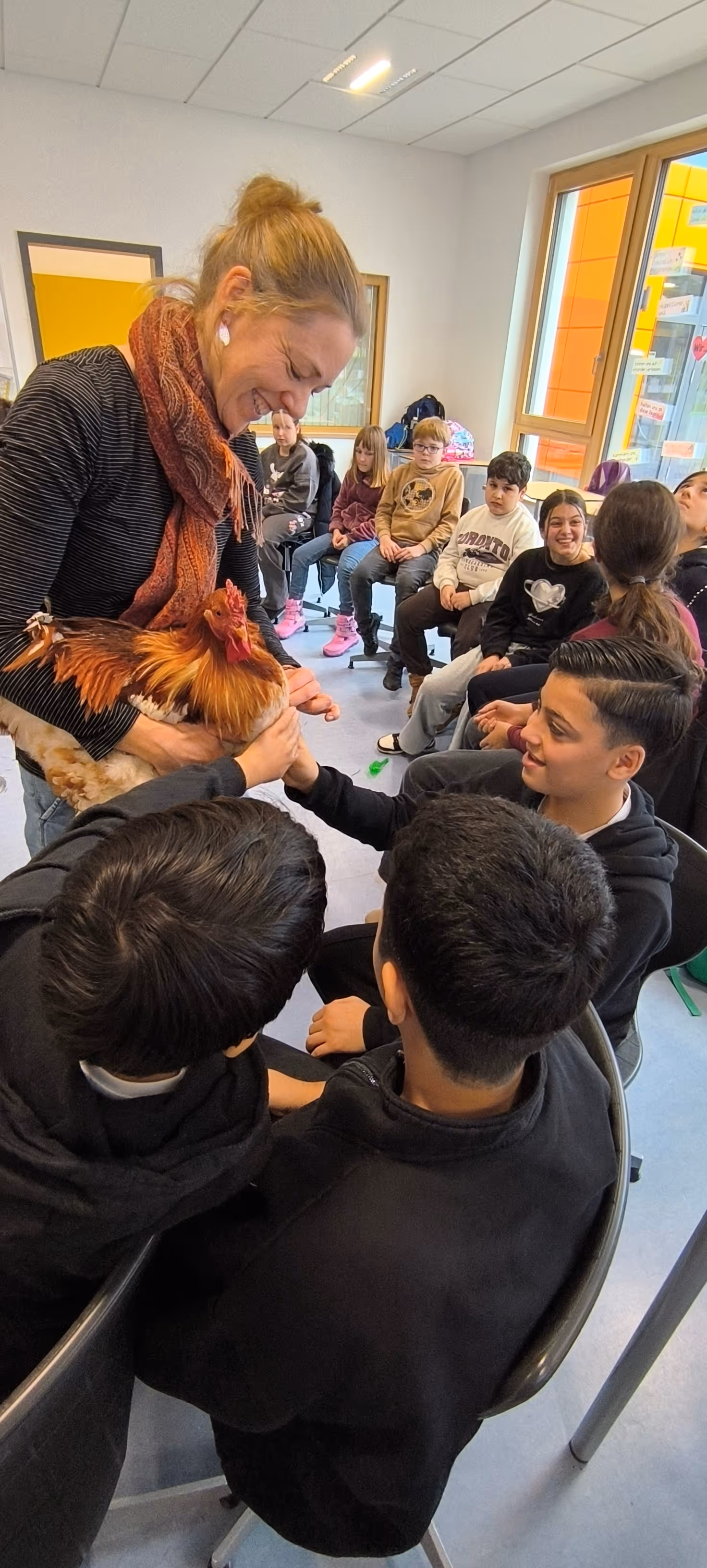 Frau Fischer zeigt Schülern den Hahn