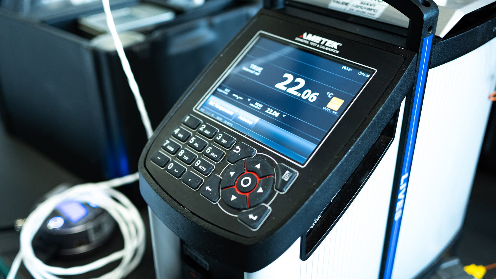 Appareil de mesure affichant une température de 22,06 degrés Celsius sur son écran numérique.