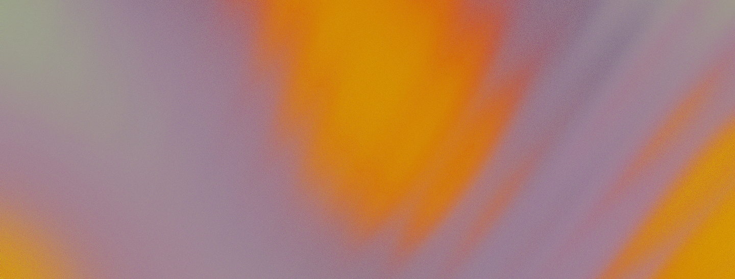 Abstract blurry background with soft gradients of orange, purple, and pale green colors.