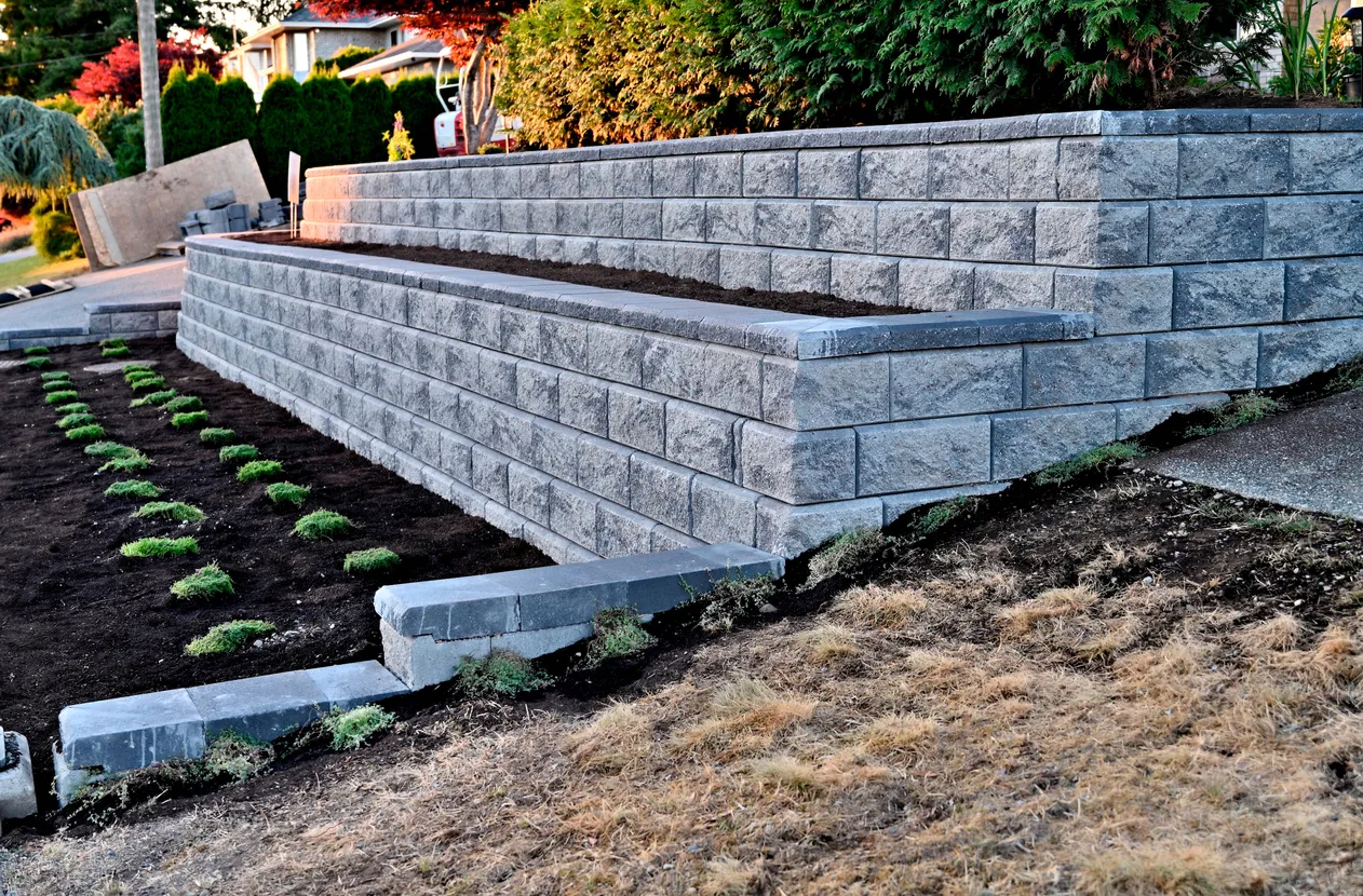 Custom stone retaining wall installed along a landscaped yard